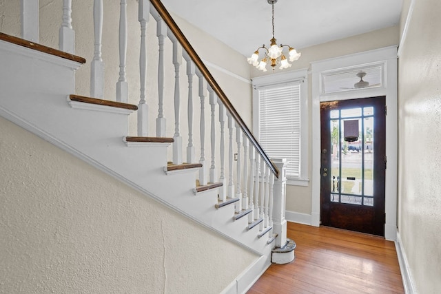 307 S Academy St, Geneva, AL 36340 - foyer entrance featuring stairway, a chandelier, wood finished floors, baseboards, and a textured wall