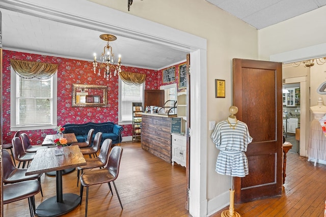 307 S Academy St, Geneva, AL 36340 - dining area with wallpapered walls, a chandelier, hardwood / wood-style flooring, ornamental molding, and healthy amount of natural light