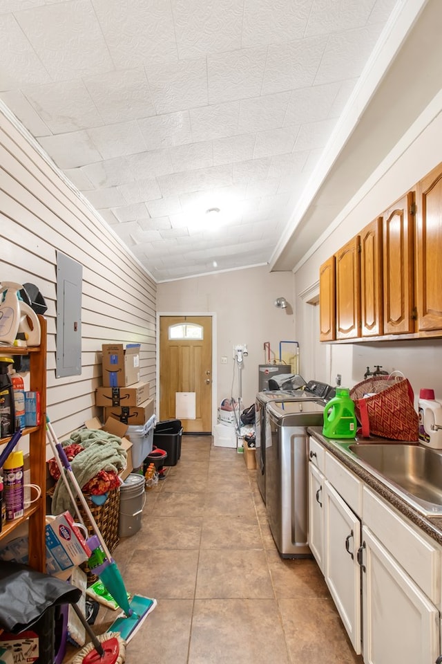 interior space with cabinets, electric panel, sink, light tile patterned floors, and independent washer and dryer