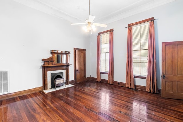 unfurnished living room with ceiling fan, a fireplace, ornamental molding, and dark wood-type flooring