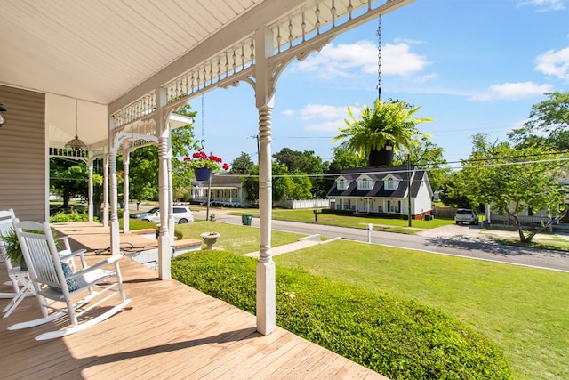 wooden terrace featuring a yard and a porch