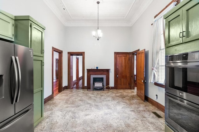 kitchen with green cabinets, ornamental molding, appliances with stainless steel finishes, and an inviting chandelier