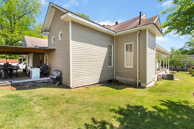 view of side of property with a patio, central AC, and a lawn