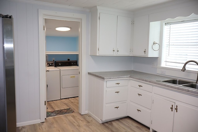 907 E Lee St, Enterprise, AL 36330 - kitchen featuring freestanding refrigerator, separate washer and dryer, light wood finished floors, a sink, and white cabinets