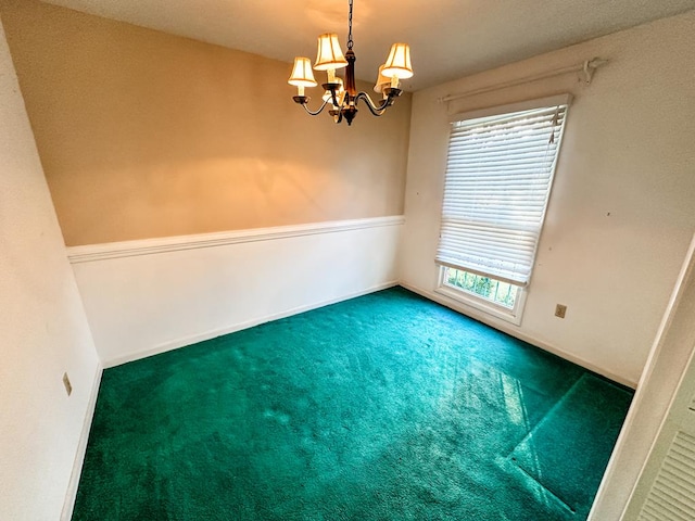 carpeted empty room featuring a healthy amount of sunlight and a notable chandelier