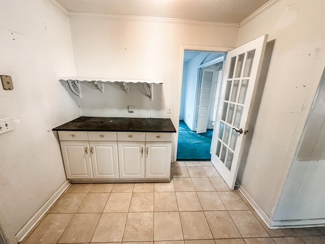 bathroom featuring tile patterned flooring, a textured ceiling, and crown molding