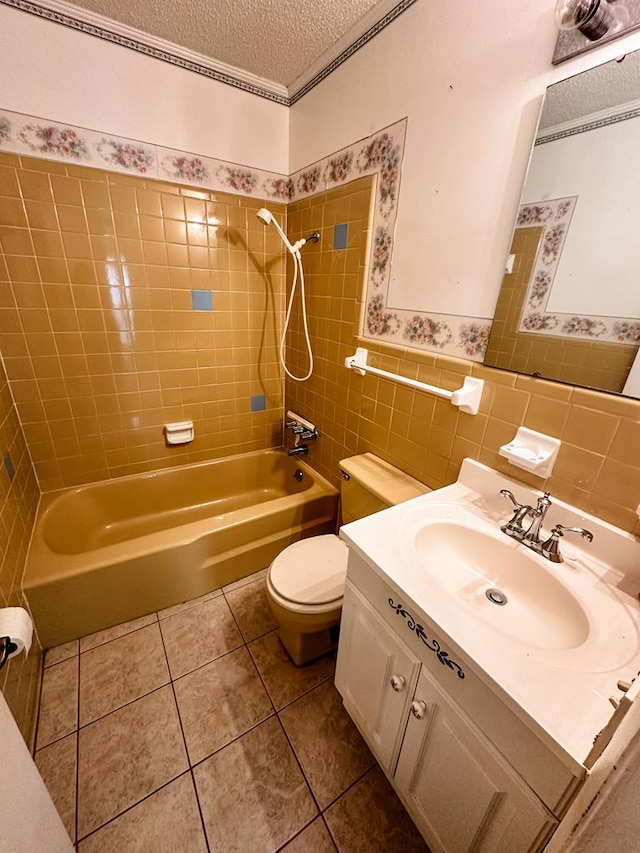 full bathroom featuring tiled shower / bath combo, tile patterned flooring, a textured ceiling, vanity, and tile walls