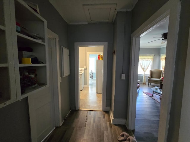 corridor with dark wood-type flooring, washer / dryer, and attic access