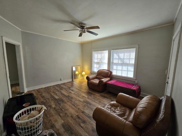 living area featuring baseboards, ceiling fan, wood finished floors, and crown molding