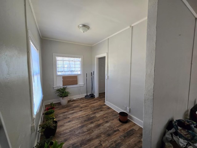 hallway featuring baseboards, crown molding, and wood finished floors