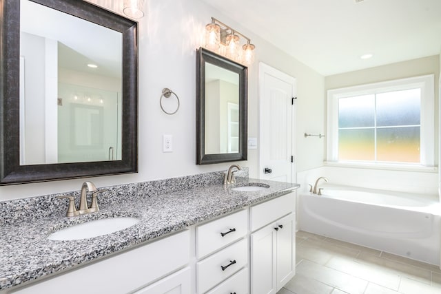 103 Cleo Ct, Enterprise, AL 36330 - bathroom featuring double vanity, a bath, tile patterned flooring, and recessed lighting