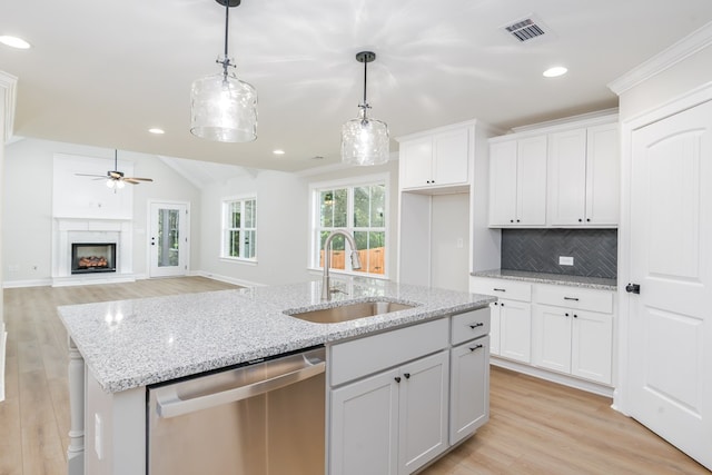 103 Cleo Ct, Enterprise, AL 36330 - kitchen with dishwasher, light wood-type flooring, backsplash, white cabinets, and vaulted ceiling