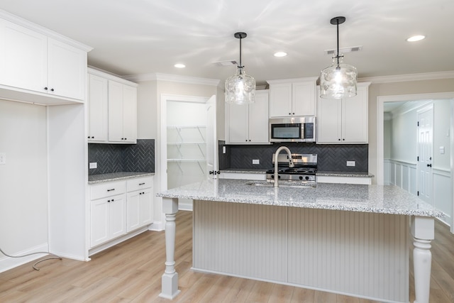 103 Cleo Ct, Enterprise, AL 36330 - kitchen with stainless steel microwave, tasteful backsplash, ornamental molding, white cabinets, and light wood-style floors