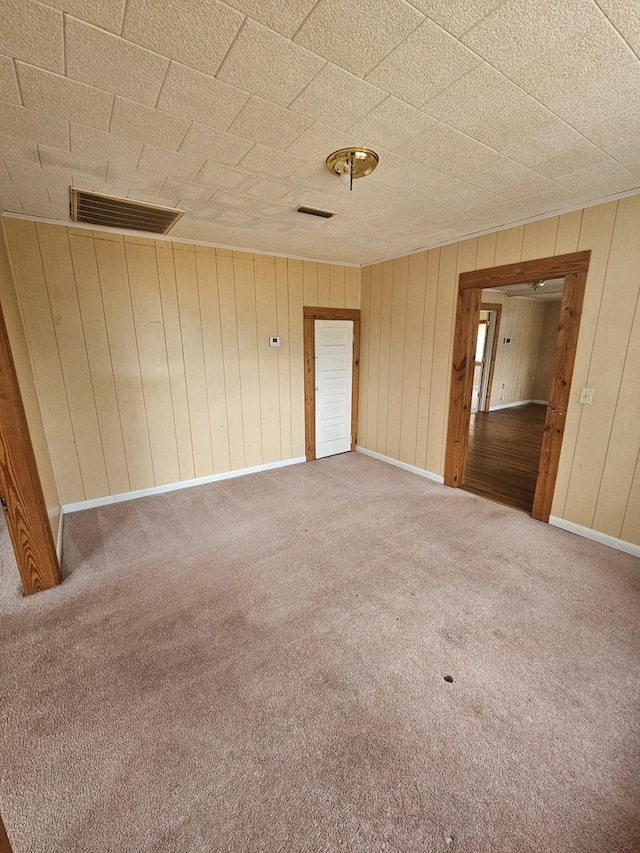 307 Rockhill Cir, Abbeville, AL 36310 - empty room with wood walls, visible vents, and carpet floors