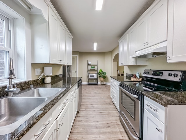 kitchen with sink, white cabinets, stainless steel appliances, and light hardwood / wood-style flooring