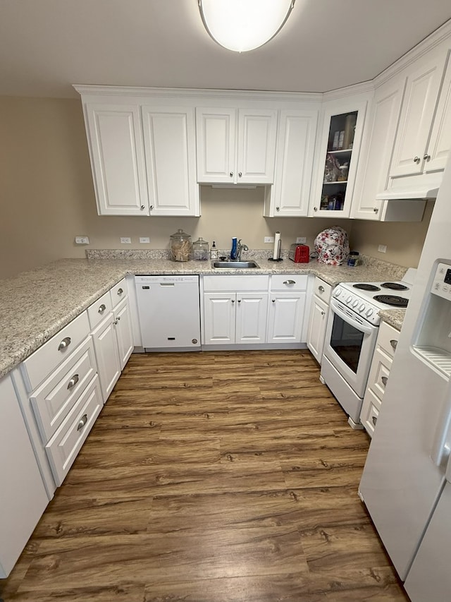 kitchen with sink, light stone counters, dark hardwood / wood-style floors, white appliances, and white cabinets