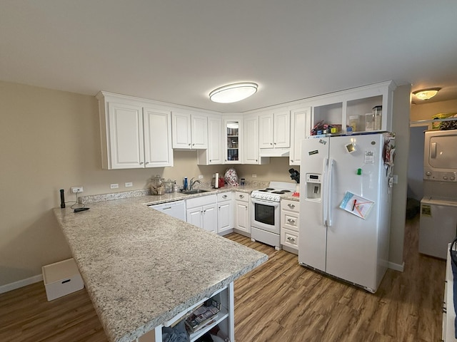 kitchen featuring white cabinetry, sink, white appliances, and kitchen peninsula