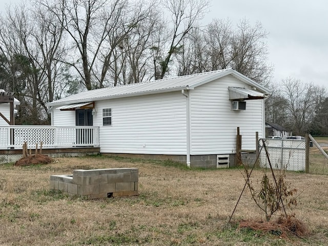 rear view of property with a wooden deck and a lawn