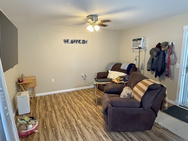 living room featuring an AC wall unit, hardwood / wood-style floors, and ceiling fan