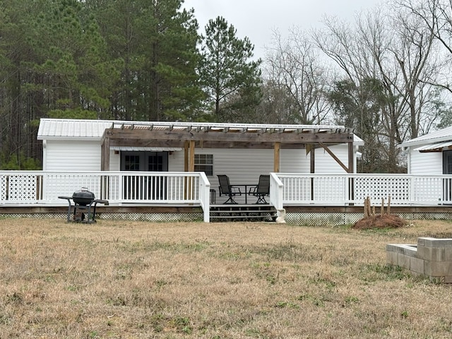 back of property featuring a wooden deck and a lawn