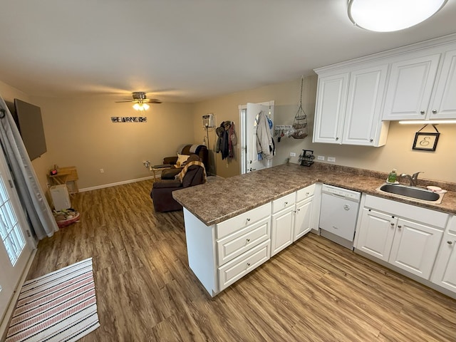 kitchen featuring sink, white cabinetry, white dishwasher, light hardwood / wood-style floors, and kitchen peninsula