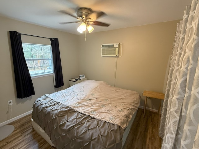 bedroom with dark wood-type flooring, a wall mounted air conditioner, and ceiling fan