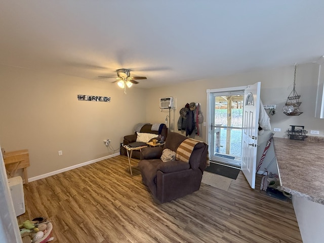 living room featuring an AC wall unit, hardwood / wood-style floors, and ceiling fan