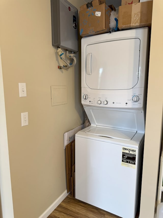 laundry room with hardwood / wood-style floors, water heater, and stacked washer / dryer