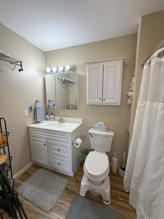 bathroom with hardwood / wood-style flooring, vanity, and toilet