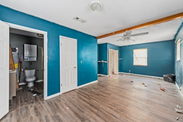 unfurnished bedroom with electric water heater, ensuite bath, ceiling fan, a textured ceiling, and wood-type flooring