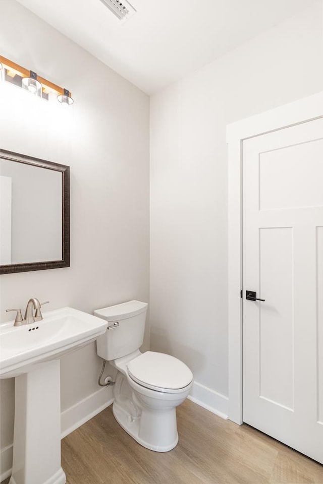 bathroom featuring hardwood / wood-style floors and toilet