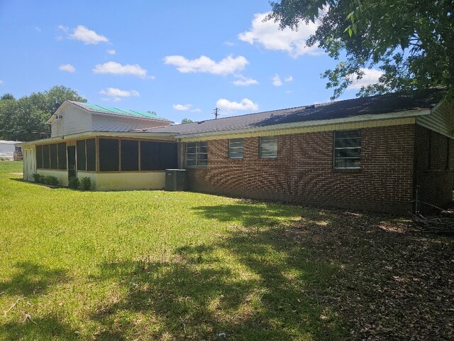 901 Grove St, Cottonwood, AL 36320 - rear view of house featuring a sunroom, brick siding, and a lawn