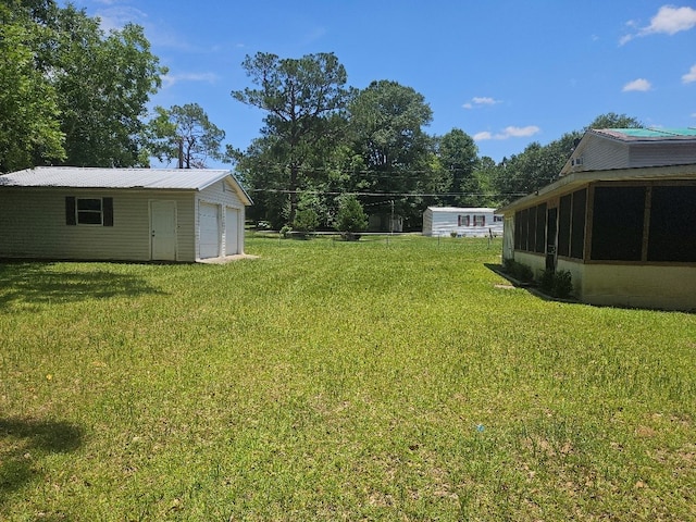 901 Grove St, Cottonwood, AL 36320 - view of grassy yard featuring a garage, a sunroom, and an outdoor structure