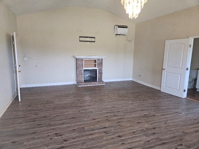 901 Grove St, Cottonwood, AL 36320 - unfurnished living room featuring vaulted ceiling, a wall mounted air conditioner, dark wood-style floors, a tile fireplace, and a chandelier
