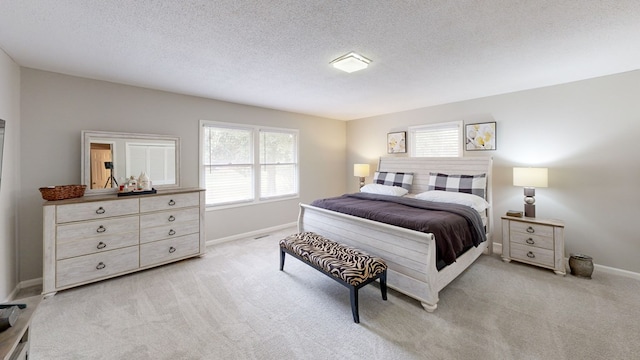 bedroom with a textured ceiling and light colored carpet