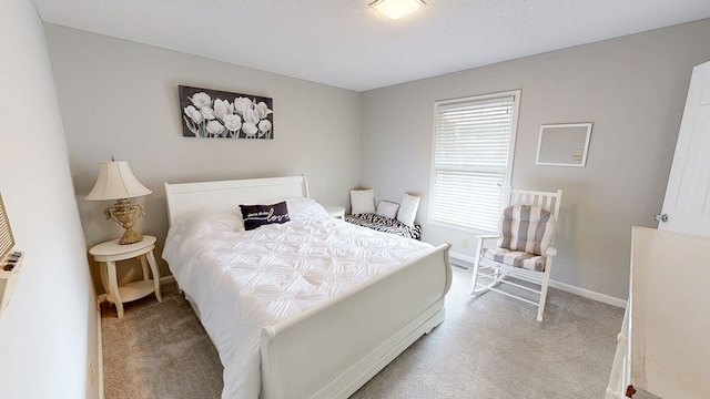 bedroom with a textured ceiling, carpet flooring, and baseboards