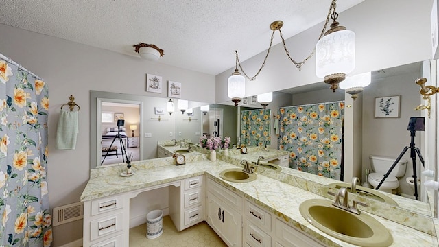 bathroom featuring toilet, a textured ceiling, lofted ceiling, a shower with shower curtain, and vanity