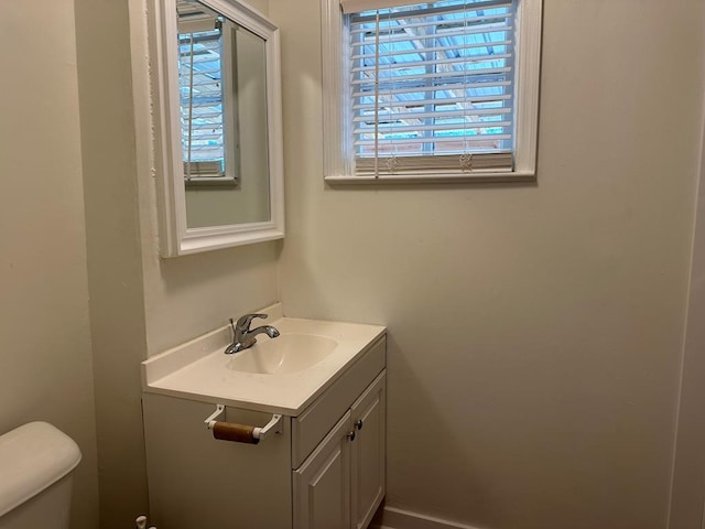 bathroom with vanity, toilet, and a wealth of natural light