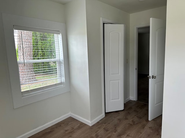 unfurnished bedroom featuring dark hardwood / wood-style flooring and multiple windows