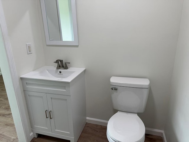 bathroom with hardwood / wood-style floors, vanity, and toilet