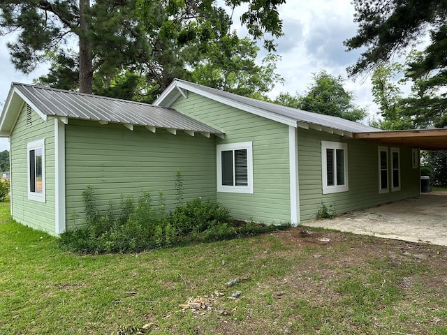 view of home's exterior featuring a carport and a yard