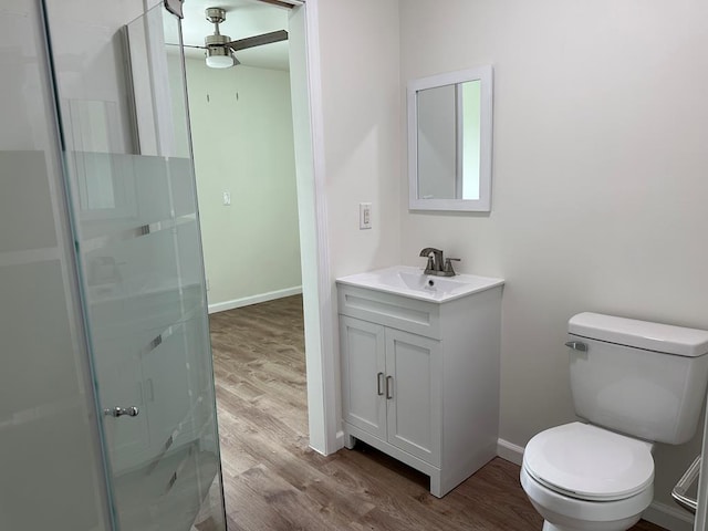 bathroom featuring hardwood / wood-style floors, vanity, ceiling fan, toilet, and an enclosed shower