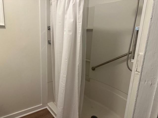 bathroom with a shower with curtain and wood-type flooring