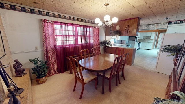 dining room featuring light colored carpet and a chandelier