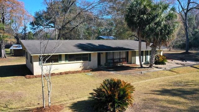 ranch-style home featuring a front lawn and brick siding