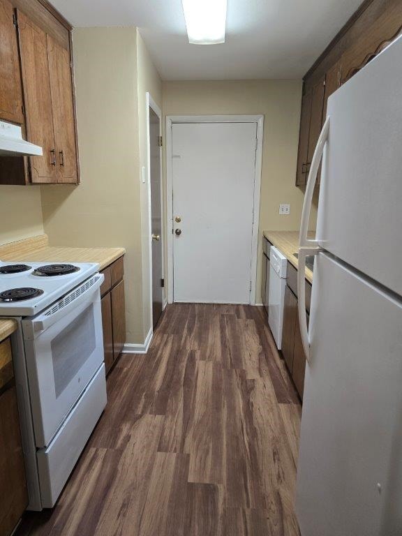 826 Old Newton Rd, Daleville, AL 36322 - kitchen featuring white appliances, under cabinet range hood, dark wood-style floors, light countertops, and brown cabinetry
