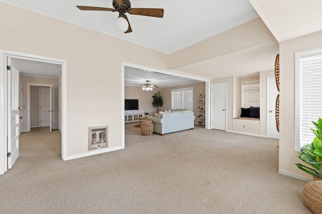 unfurnished living room featuring carpet, heating unit, ornamental molding, a ceiling fan, and baseboards