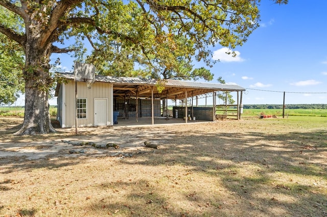 view of outdoor structure with a carport, an exterior structure, and an outbuilding