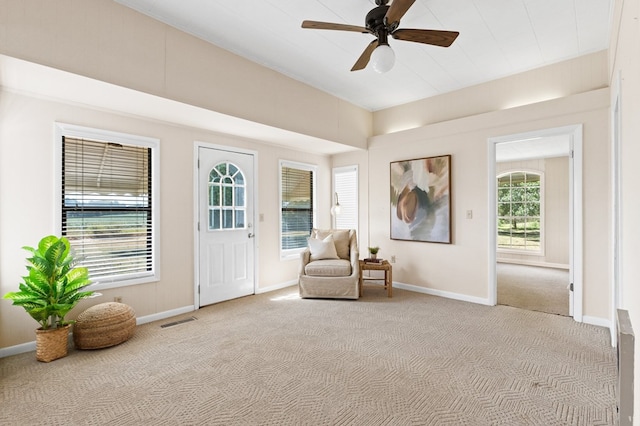 living area with carpet floors, visible vents, ceiling fan, and baseboards