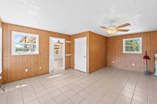 unfurnished room featuring light tile patterned flooring, a ceiling fan, and baseboards